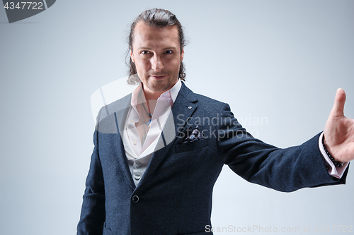 Image of The mature barded man in a suit holding cane.