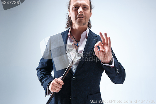 Image of The mature barded man in a suit holding cane.