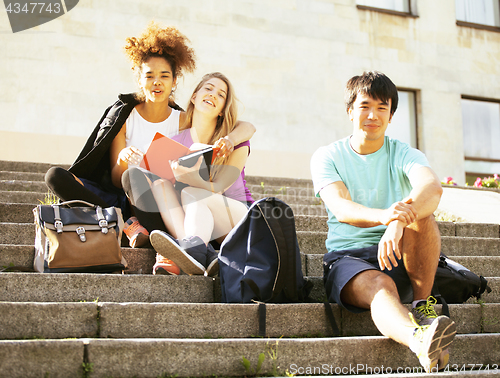 Image of cute group of teenages at the building of university with books huggings, back to school