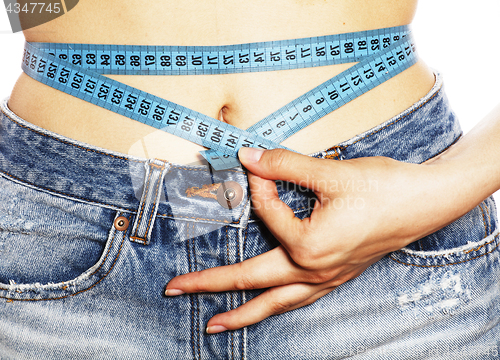 Image of girls stomach measuring with tape twice isolated close up