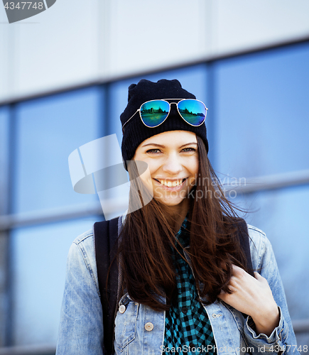 Image of young pretty girl near business building walking