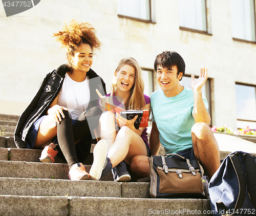 Image of cute group of teenages at the building  university with books huggings, back to school