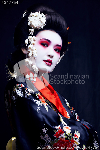 Image of young pretty geisha in kimono with sakura and decoration