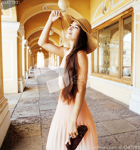 Image of young pretty smiling woman in hat with bags on shopping at store