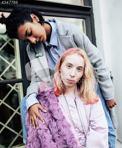 Image of Two teenage girls infront of university building smiling, having