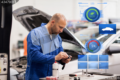 Image of mechanic man with wrench repairing car at workshop