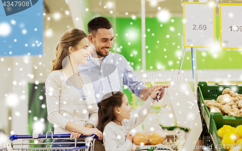 Image of family weighing oranges on scale at grocery store