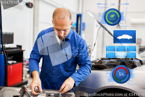 Image of mechanic man with wrench repairing car at workshop