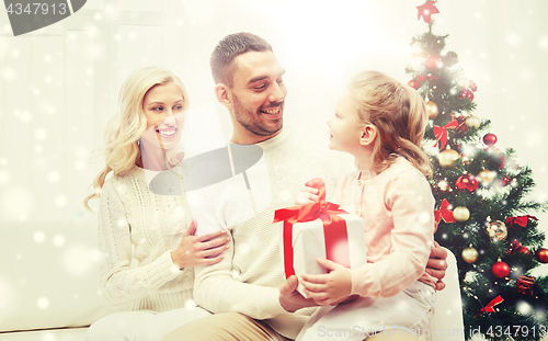 Image of happy family at home with christmas gift