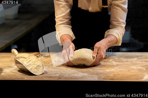 Image of baker making bread dough at bakery kitchen