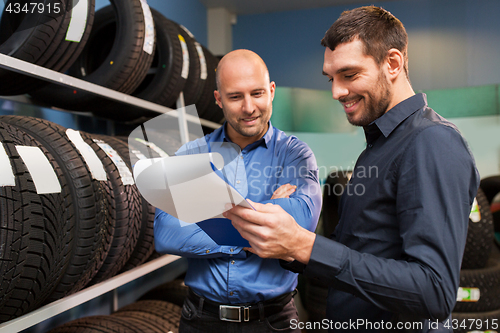 Image of customer and salesman at car service or auto store