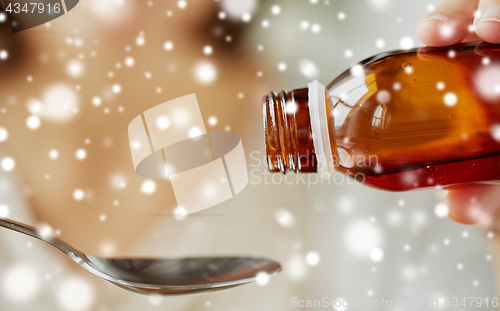 Image of woman pouring medication from bottle to spoon