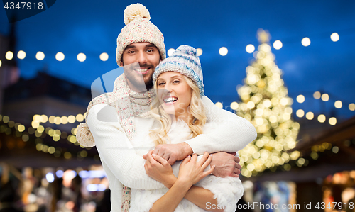 Image of happy couple hugging over christmas tree lights