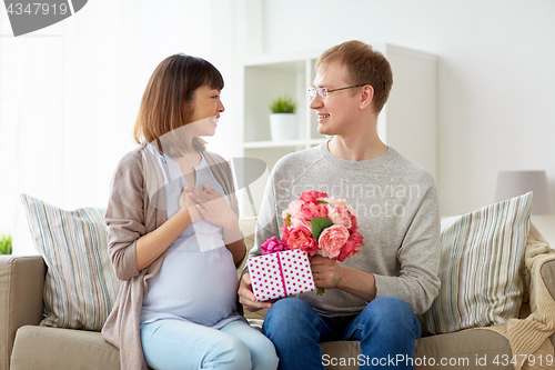 Image of happy husband giving present to his pregnant wife