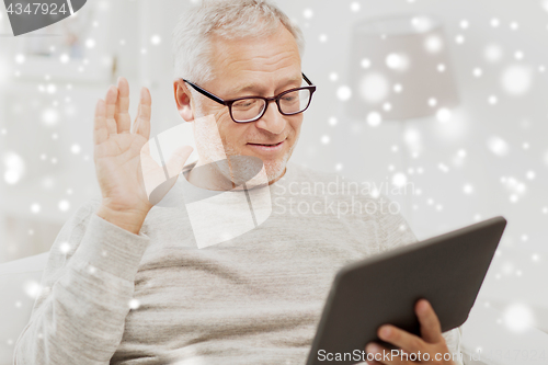 Image of senior man having video call on tablet pc at home