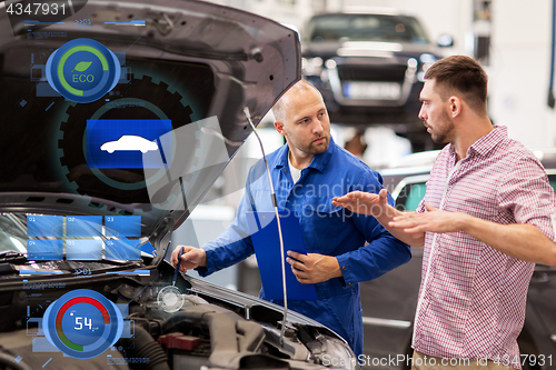 Image of auto mechanic with clipboard and man at car shop