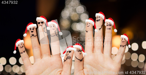 Image of hands and fingers in santa hats at christmas