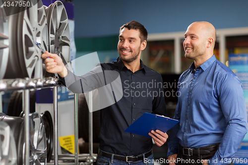 Image of customer and salesman at car service or auto store