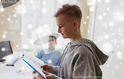 Image of student boy with notebook and teacher at school