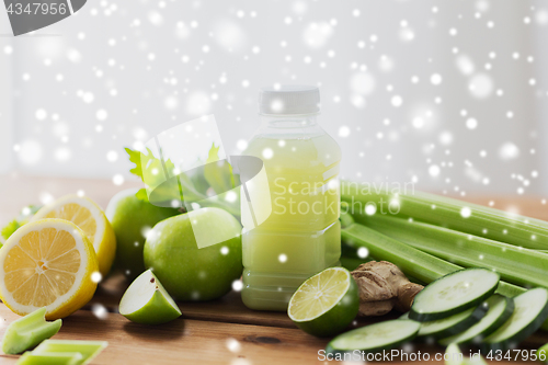 Image of bottle with green juice, fruits and vegetables