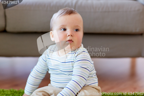 Image of baby boy sitting on floor at home