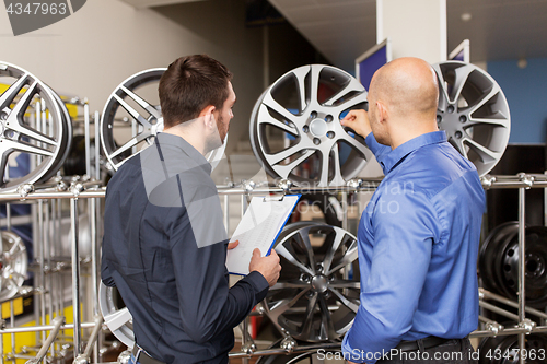 Image of customer and salesman at car service or auto store