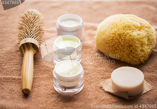 Image of hair brush, cream, sponge, soap bar and bath towel