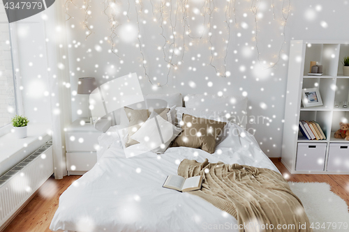 Image of bedroom with bed and christmas garland at home