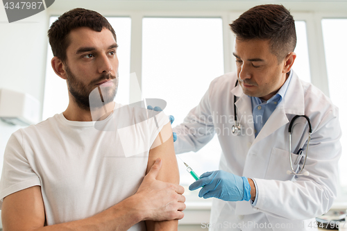 Image of patient and doctor with syringe doing vaccination