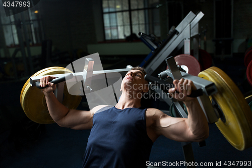 Image of man doing chest press on exercise machine in gym