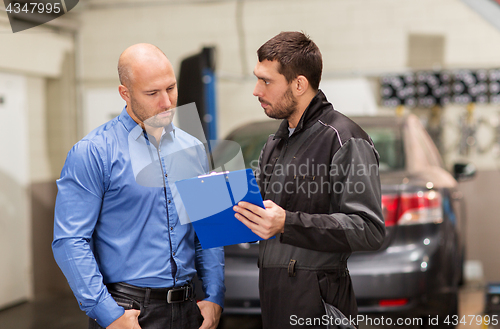 Image of auto mechanic and customer at car shop