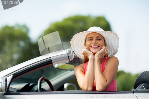 Image of happy young woman in convertible car