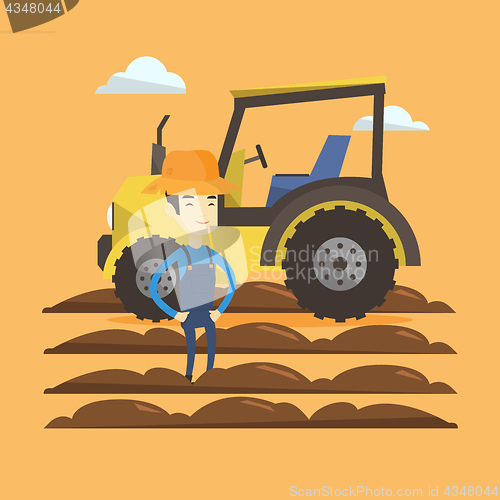 Image of Farmer standing with tractor on background.