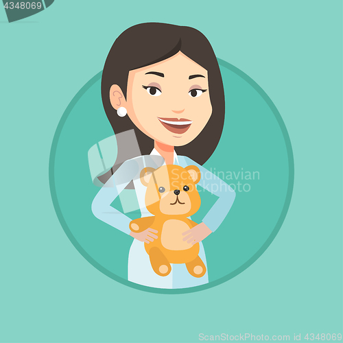 Image of Pediatrician doctor holding teddy bear.