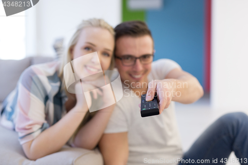 Image of Young couple on the sofa watching television