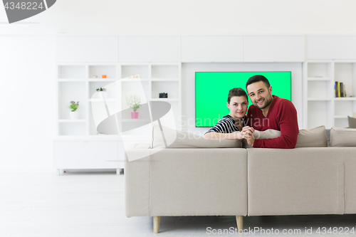 Image of couple hugging and relaxing on sofa