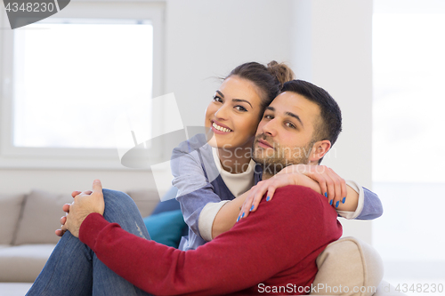 Image of couple hugging and relaxing on sofa