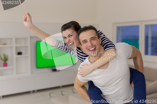 Image of handsome man piggybacking his girlfriend