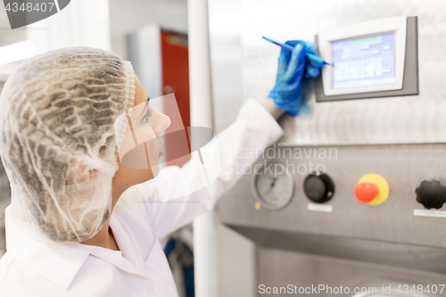 Image of woman programming computer at ice cream factory