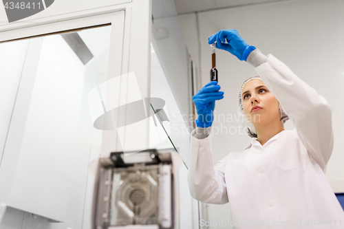 Image of woman with sulphuric acid in dropper at laboratory
