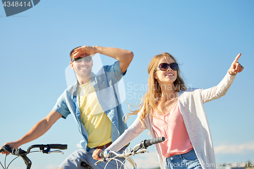 Image of happy young couple with bicycles outdoors