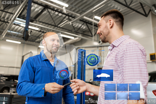 Image of auto mechanic giving key to man at car shop