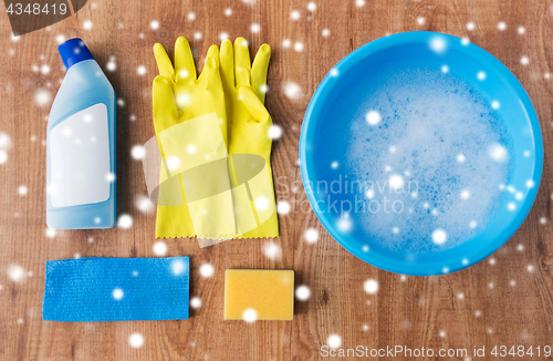 Image of basin with cleaning stuff on wooden background