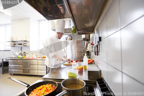 Image of male chef cooking food at restaurant kitchen