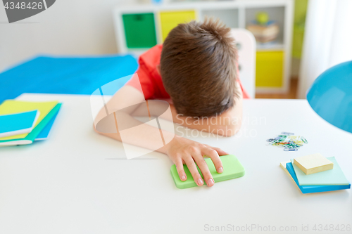 Image of tired or sad student boy with smartphone at home