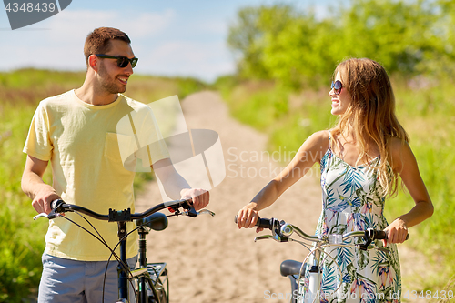 Image of happy couple with bicycles on country road