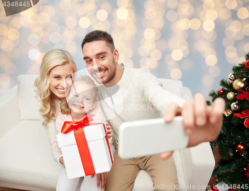 Image of family taking selfie with smartphone at christmas