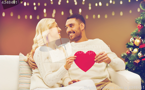 Image of happy couple with red heart at christmas