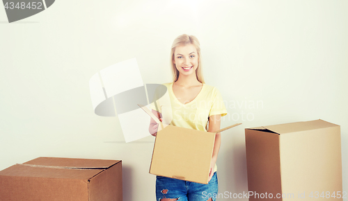 Image of smiling young woman with cardboard box at home