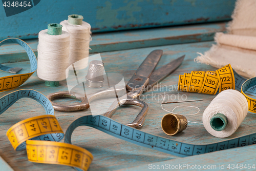 Image of Retro sewing accessories on blue wooden background